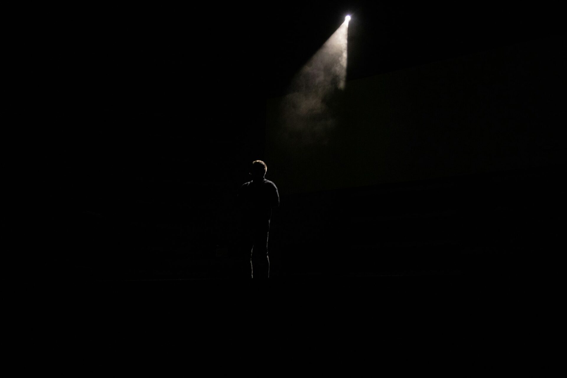 A speaker in a single spotlight on stage